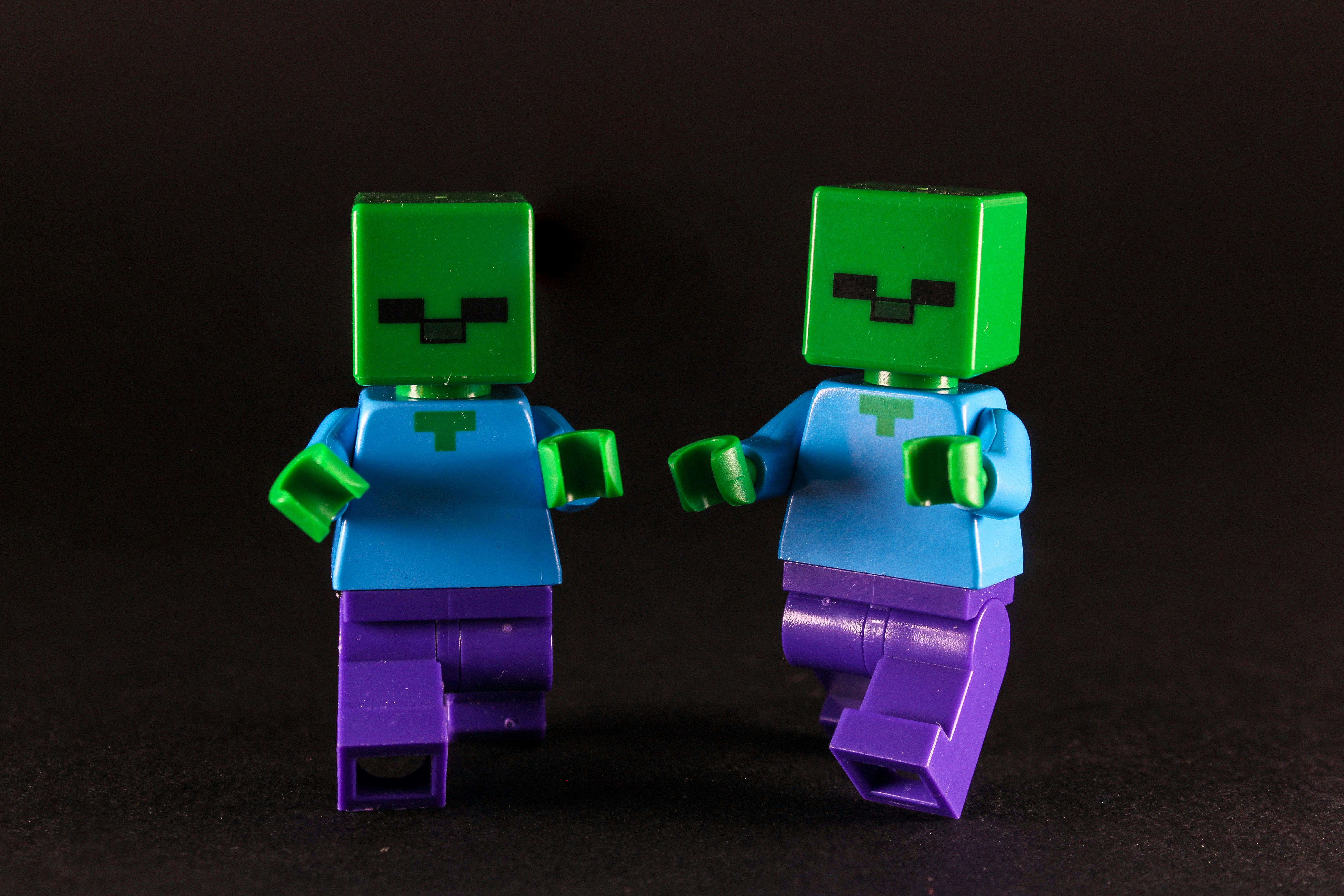 Two green-headed figures with blue shirts and purple pants